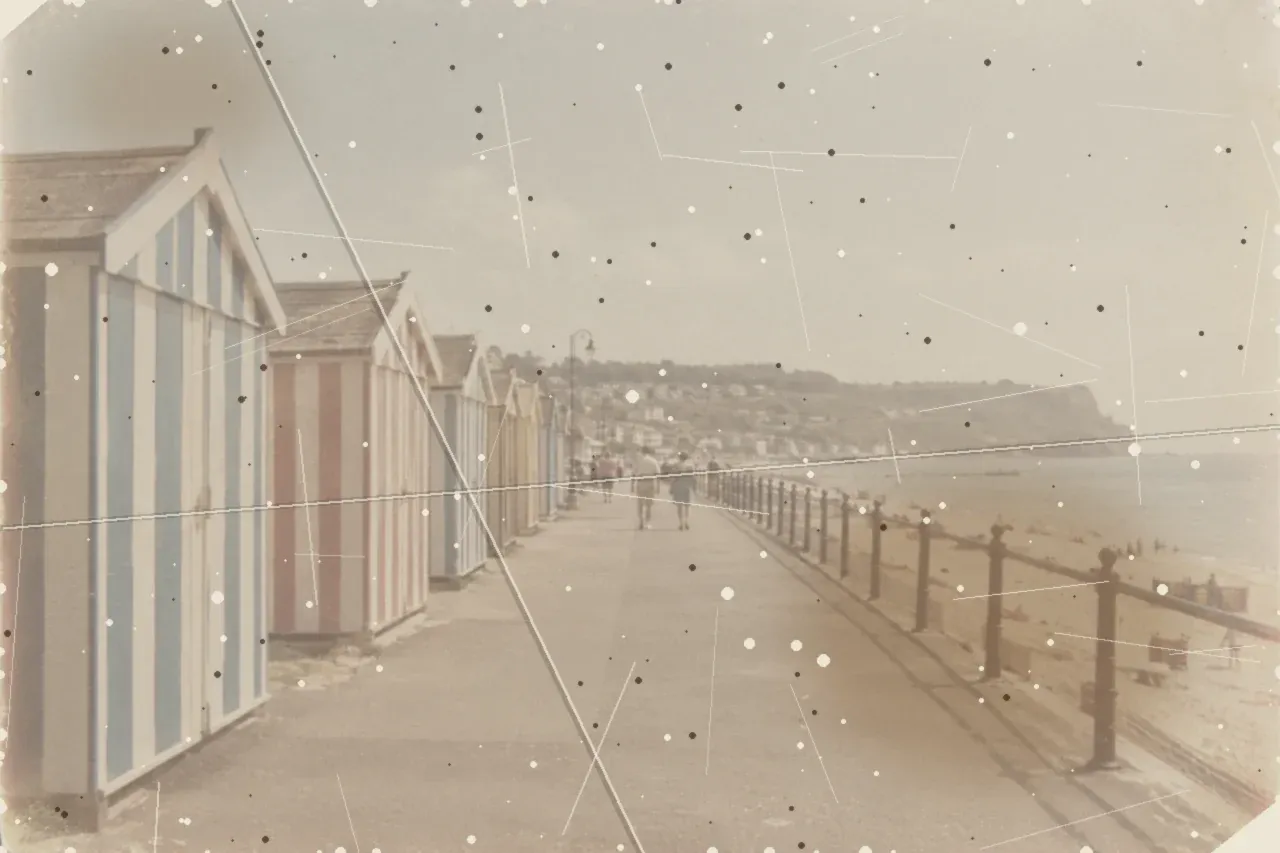 Before, seaside print restoration: a simulated damaged print: a generated image with damage added digitally, not a real damaged photo